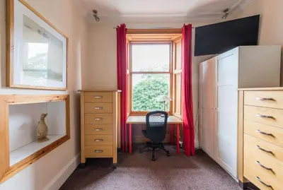 a bedroom with a desk and a window at 3 bed overlooking meadows park in Edinburgh