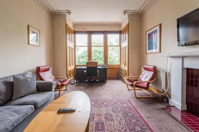 a living room with a couch and a fireplace at 3 bed overlooking meadows park in Edinburgh