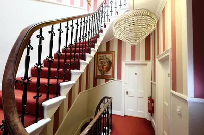 a hallway with a spiral staircase in a house at Balmore Guest House in Edinburgh