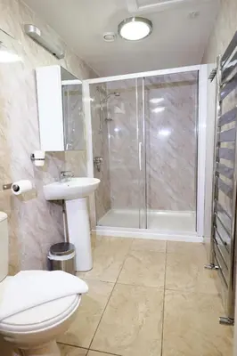 a bathroom with a shower and a toilet and a sink at Balmore Guest House in Edinburgh