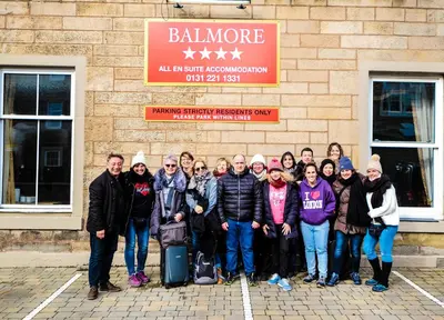 a group of people posing for a picture in front of a building at Balmore Guest House in Edinburgh
