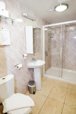 a bathroom with a toilet and a shower and a sink at Balmore Guest House in Edinburgh