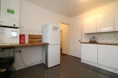 a kitchen with white cabinets and a white refrigerator at Signature - Glen Lee House in Glasgow