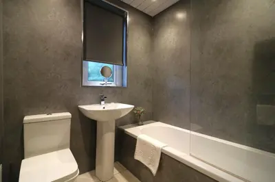 a bathroom with a sink and a toilet and a bath tub at Signature - Glen Lee House in Glasgow