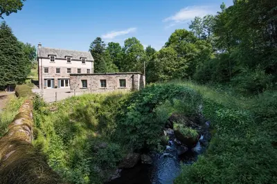 an old building and a bridge over a river at Mill House Monzie in Crieff