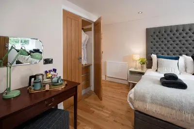 a bedroom with a bed and a desk with a mirror at Mill House Monzie in Crieff