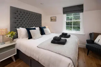 a bedroom with a large bed with two towels on it at Mill House Monzie in Crieff