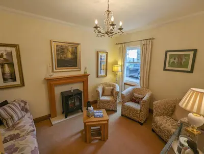 a living room with a couch and a fireplace at Arden Country House in Linlithgow