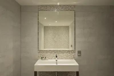 a bathroom with a white sink and a mirror at Radstone Hotel in Larkhall