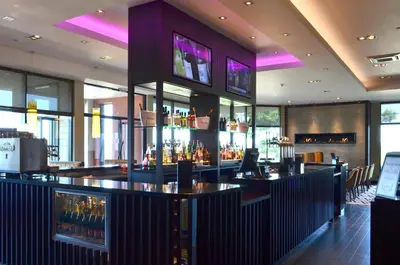a bar in a restaurant with a lot of windows at Radstone Hotel in Larkhall
