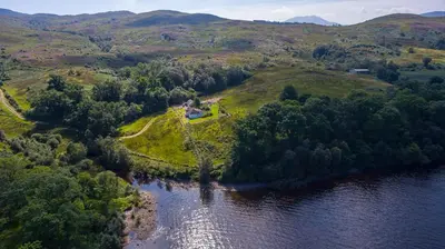 an aerial view of a house on an island in the water at Burn View in Stronachlachar