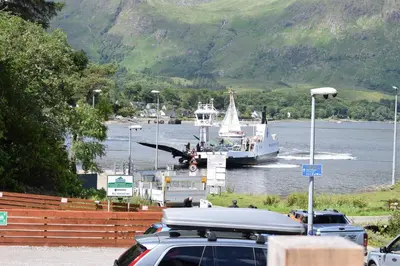 a boat in the water with a plane on a dock at The Corran in Onich