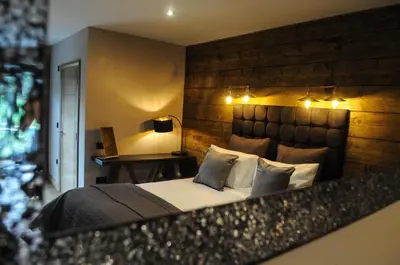 a bedroom with a large bed with a wooden headboard at The Corran in Onich