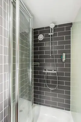 a bathroom with a shower with a glass door at Holiday Inn Express Strathclyde Park M74, Jct 5 by IHG in Motherwell