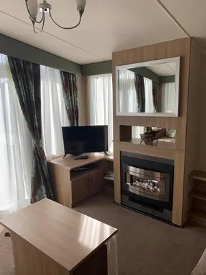 a living room with a fireplace and a television at Swift bordeaux 24 in Dunoon