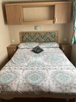 a bed with a quilt on it in a bedroom at Swift bordeaux 24 in Dunoon