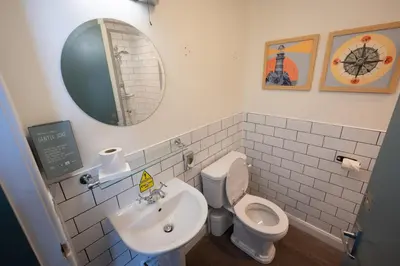 a bathroom with a sink and a toilet and a mirror at Ardencaple Hotel by Greene King Inns in Helensburgh