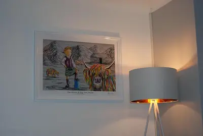 a picture hanging on a wall next to a lamp at No27 Ayr Beach - Coorie Doon Stays in Ayr