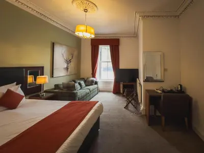a hotel room with a bed and a couch at The Crags Hotel in Callander