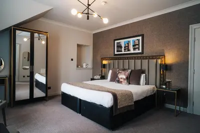 a bedroom with a large bed and a mirror at Number 10 Hotel in Glasgow