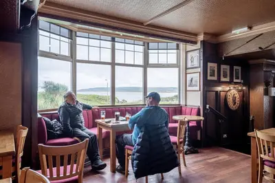 two people sitting at a table in a restaurant at The Ugadale Hotel in Campbeltown
