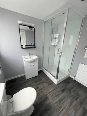 a bathroom with a toilet and a glass shower at The Kelvin Hotel in Oban