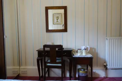 a desk with a chair and a table with a mirror at Ashgrove House in Edinburgh