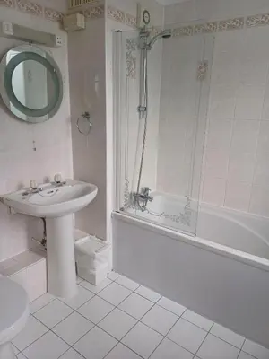 a bathroom with a sink and a shower and a tub at Kings Park Hotel in Glasgow