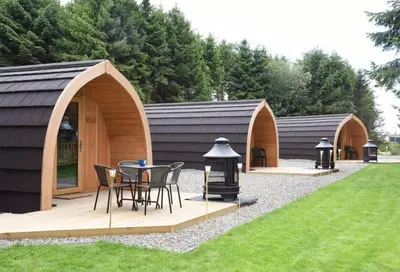 a wooden gazebo with a table and chairs in a yard at Kersebrock Kabins in Falkirk