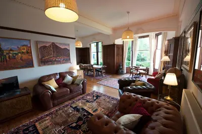 a living room with leather couches and a living room with a table at Warriston Apartment at Holm Park in Moffat