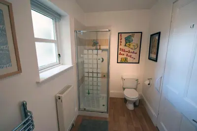 a bathroom with a toilet and a glass shower at Warriston Apartment at Holm Park in Moffat