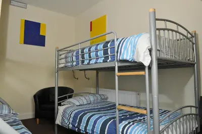 a bunk bed room with two beds and a chair at The Hostel in Edinburgh