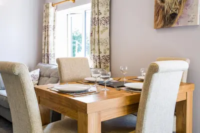 a dining room table with chairs and a wooden table at Oakbank Farm in Lamlash