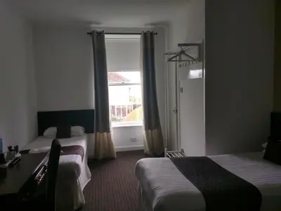 a hotel room with two beds and a window at The Park Hotel in Dunoon