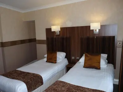 a hotel room with two beds and two lamps at The Park Hotel in Dunoon