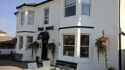 a white building with a table and chairs in front of it at The Park Hotel in Dunoon