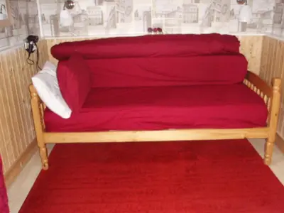 a red couch with a red blanket on it at Nethermains House in Kilwinning