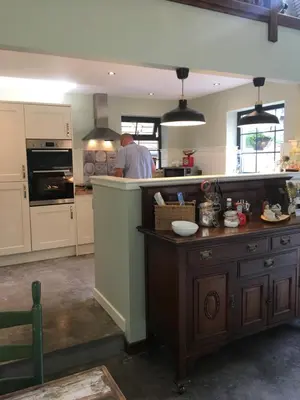 a kitchen with a man standing in the kitchen at Rosemount Boutique B&B in Lanark