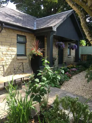 a garden in front of a house with a bench at Rosemount Boutique B&B in Lanark