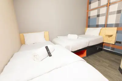 two beds in a small room with white sheets at easyHotel Glasgow City in Glasgow