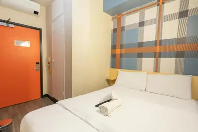 a room with a bed with a phone on it at easyHotel Glasgow City in Glasgow