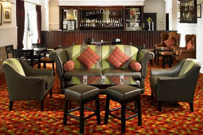 a bar with chairs and a table in a room at Dalmahoy Hotel & Country Club in Edinburgh