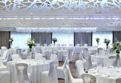 a banquet hall with white tables and white chairs at Dalmahoy Hotel & Country Club in Edinburgh