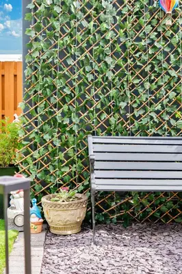 a bench sitting in front of a wall with plants at Crewe Apartment - Stylish 2 bedroom apt, Garden, Free parking, Edin City in Edinburgh