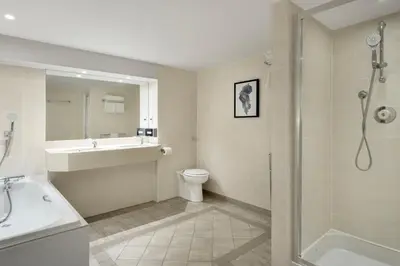 a bathroom with a sink and a shower and a toilet at Delta Hotels by Marriott Edinburgh in Edinburgh