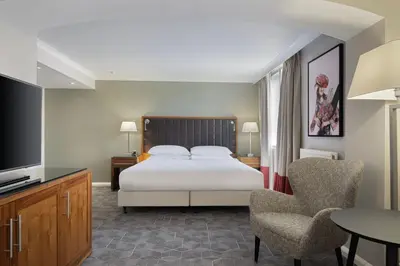 a bedroom with a bed and a tv and a chair at Delta Hotels by Marriott Edinburgh in Edinburgh