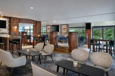 a lobby with tables and chairs and a bar at Delta Hotels by Marriott Edinburgh in Edinburgh
