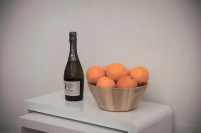 a bottle of wine next to a bowl of oranges at Edinburgh, Stockbridge Apartment in Edinburgh