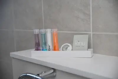 a shelf in a bathroom with toothbrushes and a clock at Edinburgh, Stockbridge Apartment in Edinburgh