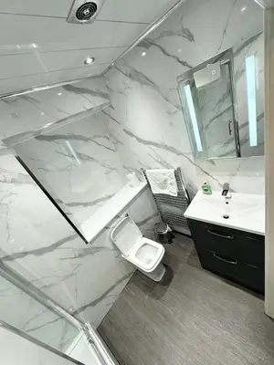 a bathroom with a sink and a white marble wall at Murrayfield Park Guest House in Edinburgh